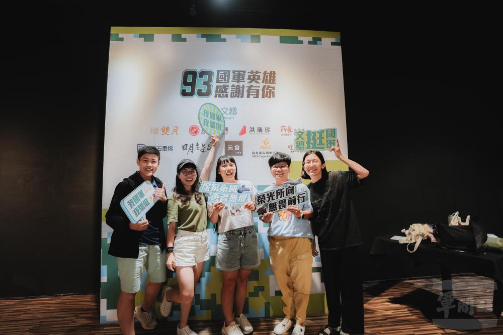 國軍官兵與眷屬於「93英雄照相館」手持應援標語合影，留下軍人節溫馨回憶。（軍聞社記者劉哲宇攝）