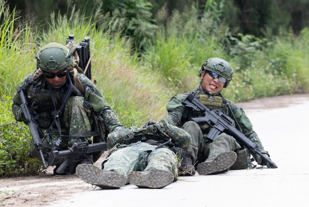 人員中彈倒地，隊友準備移動傷患至隱伏區。（軍聞社記者吳柏融攝）