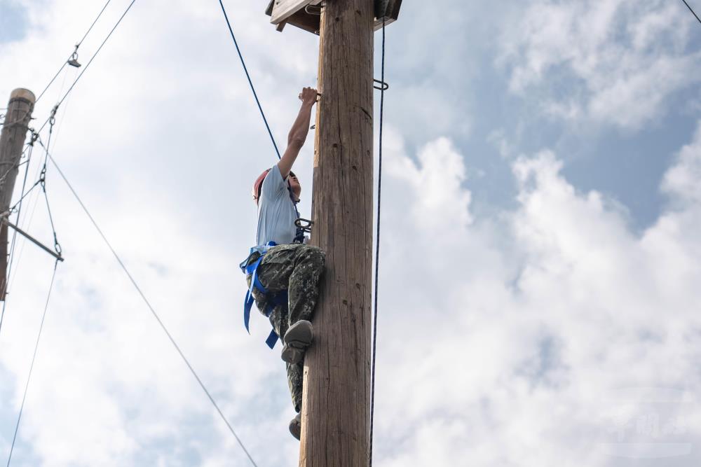 學員在教官與隊輔引導下，逐步攀爬上高臺。（軍聞社記者林庭暉攝）