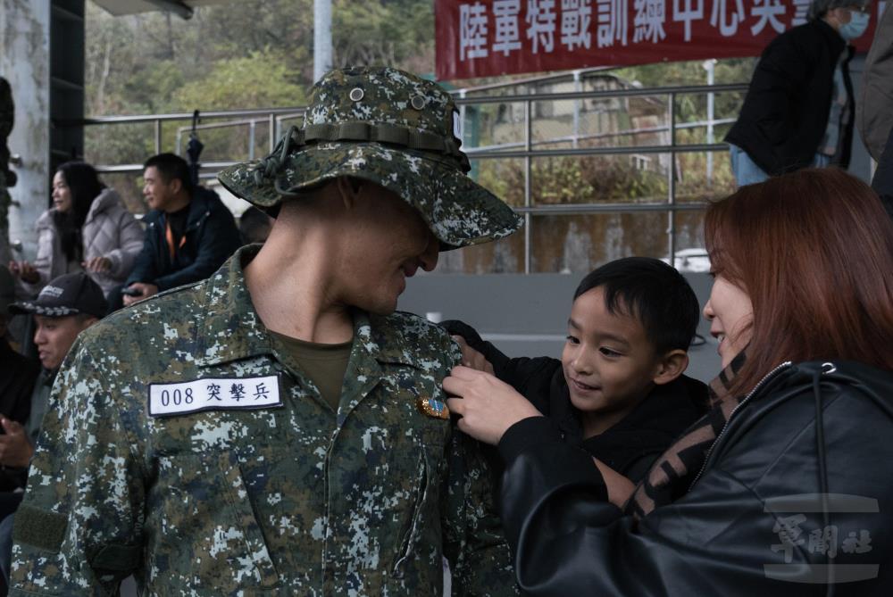 家屬為學員配掛突擊臂章。（軍聞社記者李恬恬攝）