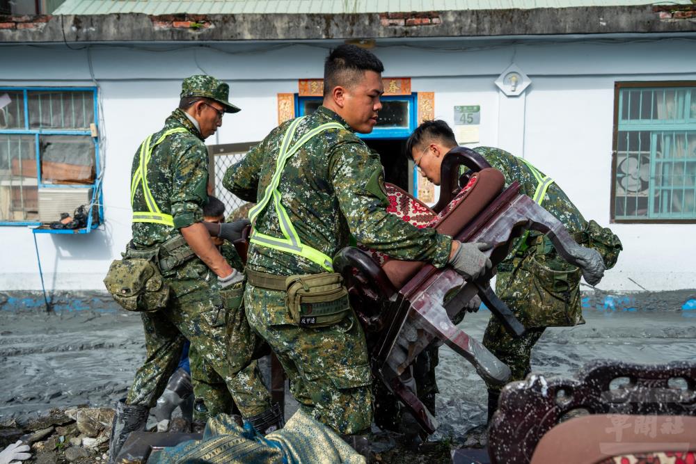 官兵與民眾協力搬運大型物品。（軍聞社記者薛皓文攝）