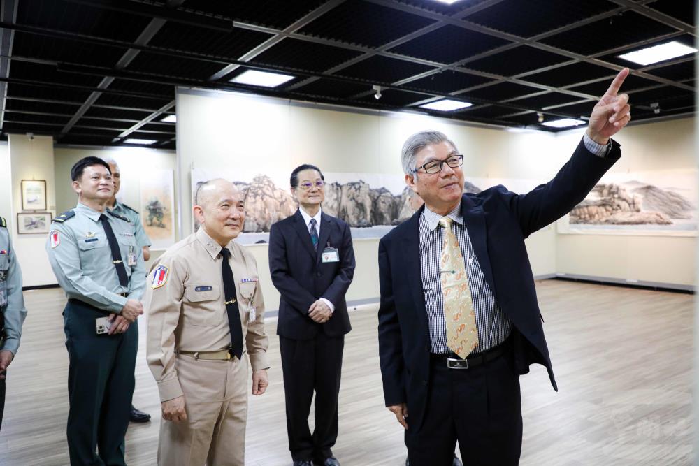 藝術家陳合成於展場分享創作歷程與藝術理念，透過細膩筆觸描繪戰地景觀與自然山海之美。（軍聞社實習記者洪廉雲攝）