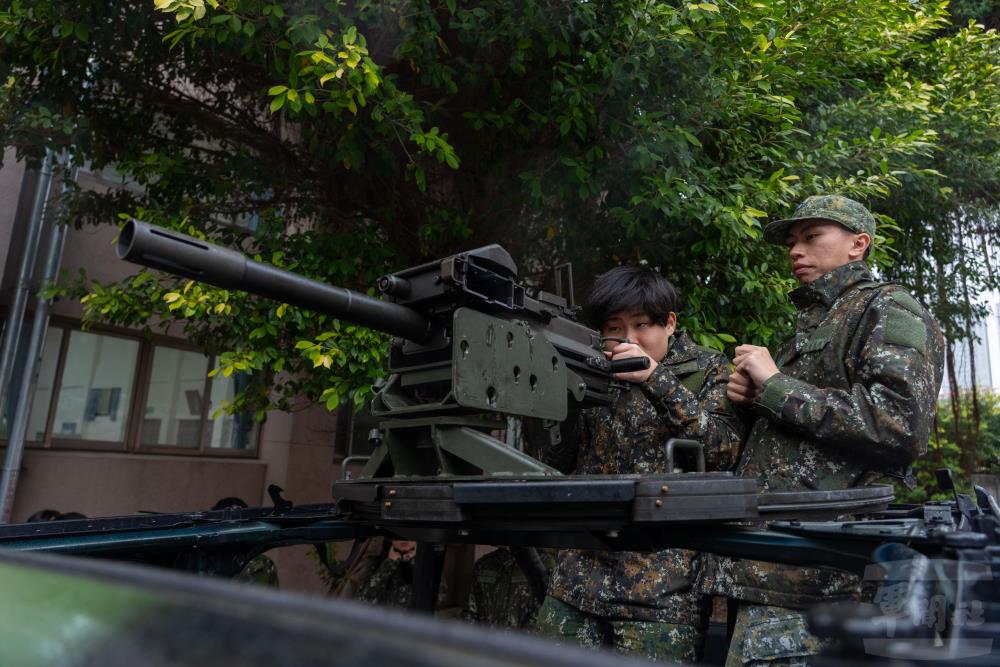學員們依序參訪各項裝備陳展，近距離了解武器性能與操作要領。（軍聞社記者吳東昇攝）