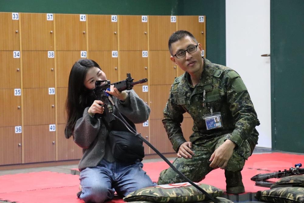 官兵眷屬體驗射擊模擬器操作。（關指部提供）