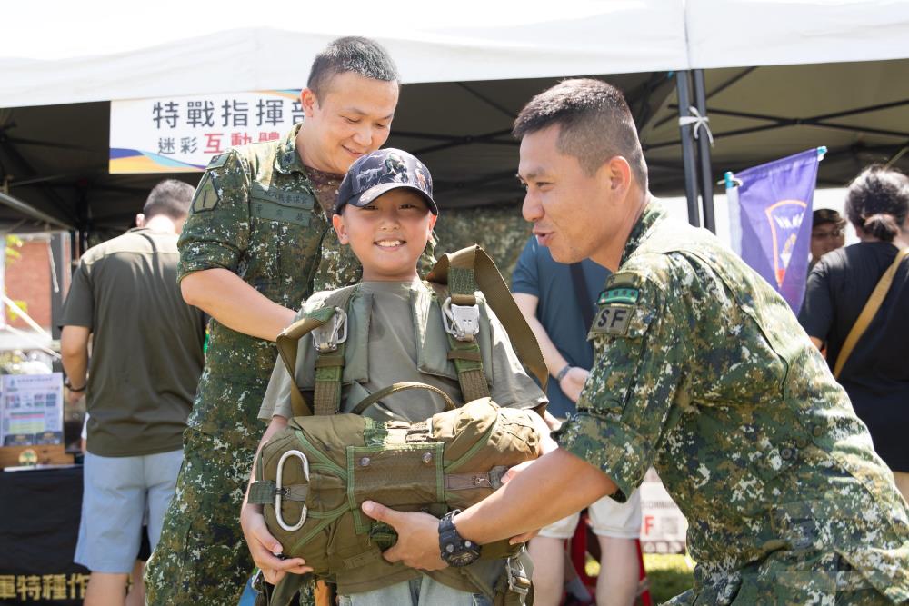 國防部全動署後備指揮部20日舉辦「全民國防教育走入鄉里」活動，民眾體驗特戰傘兵裝備。（軍聞社記者卓以立攝）