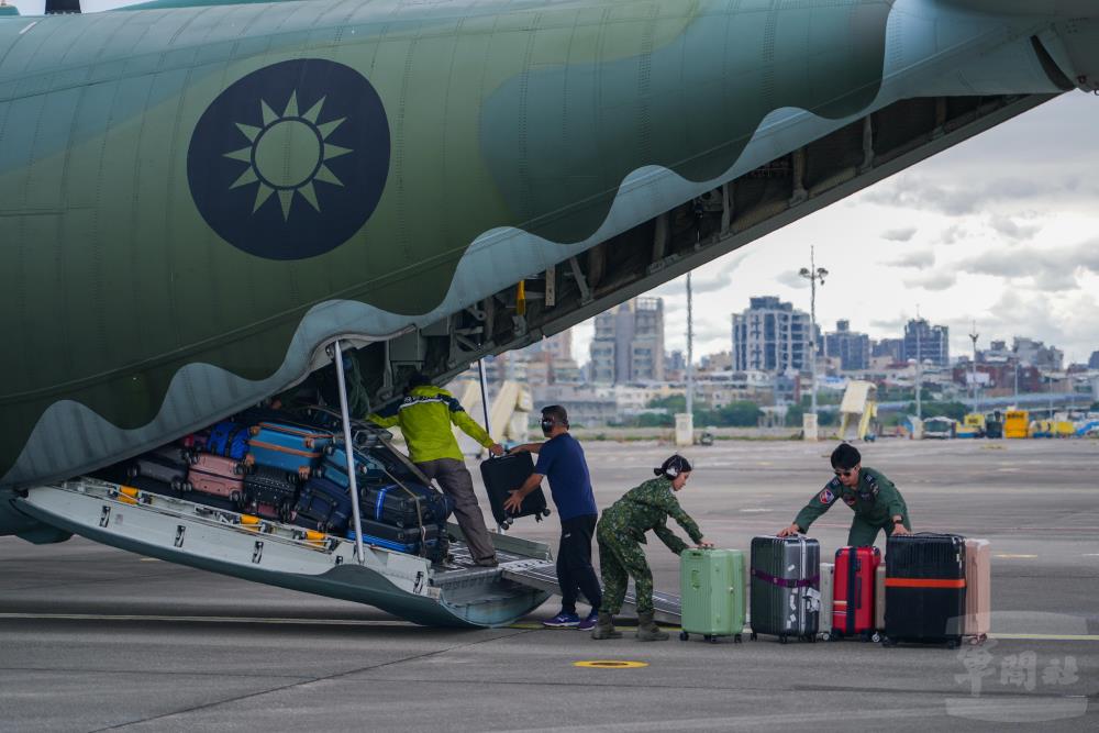 機組與地勤人員協助民眾搬運行李，確保登機動線安全順遂。（軍聞社記者陳彥樺攝）