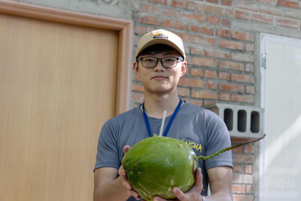 研習營學生在艷陽下實施淨灘活動後，飲用冰涼的椰子水，享受南島風情。（軍聞社記者李恬恬攝）