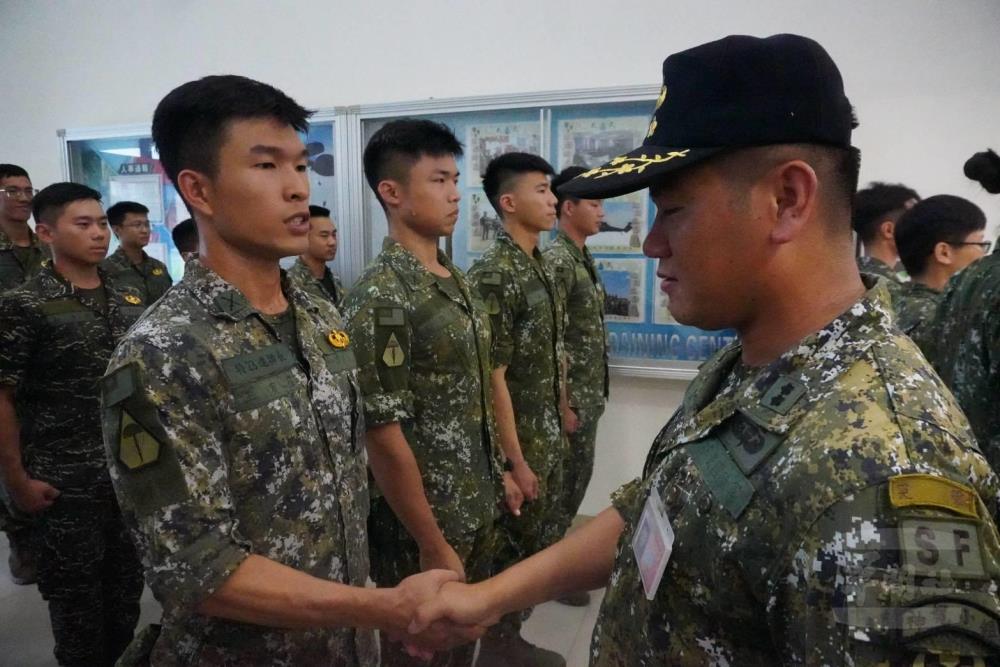 空訓中心傘教組教官為完訓學員別上傘徽。（青年日報提供）