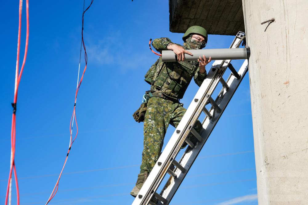 官兵於橋腳裝填爆藥。（軍聞社記者黃劭恩攝）