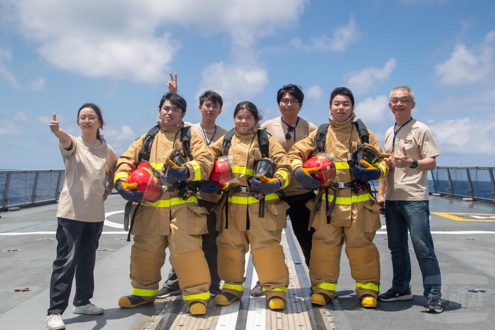 參研師生體驗防火服著裝。（軍聞社記者王進福攝）