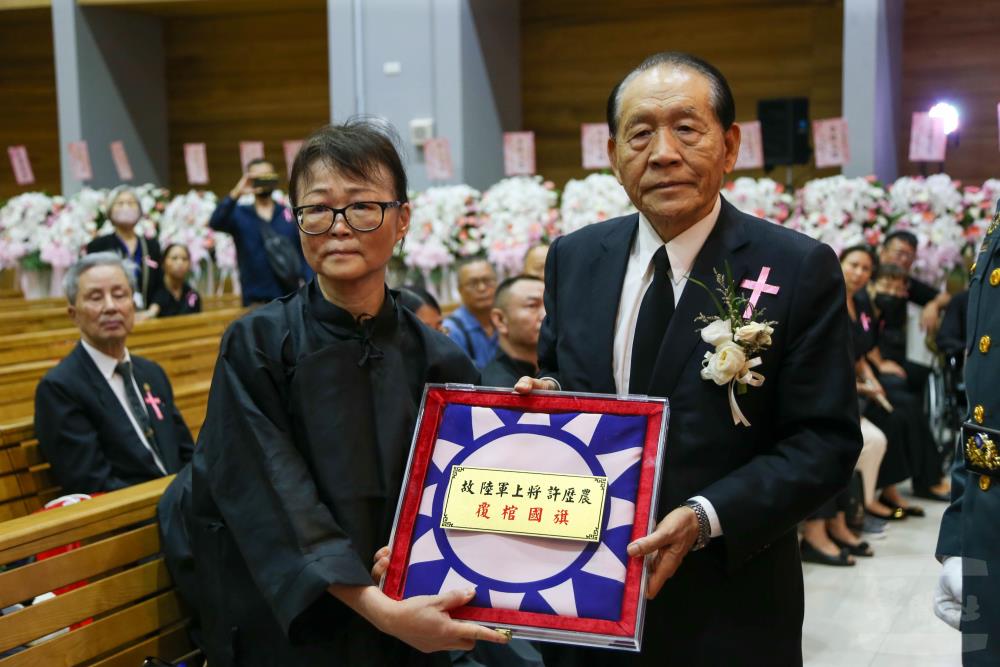 國防安全研究院董事長霍守業一級上將將國旗贈與家屬。（軍聞社記者侯凱議攝）