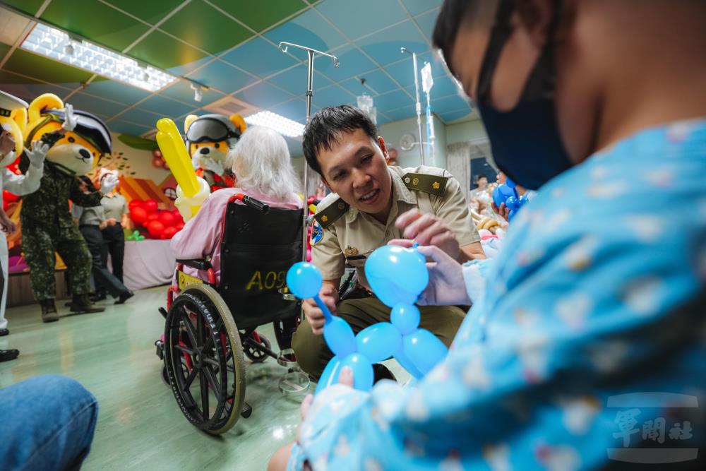 軍備局第205廠高家祥少校以造型氣球與病童親切互動，為病房注入歡笑與溫暖。（軍聞社記者劉哲宇攝）