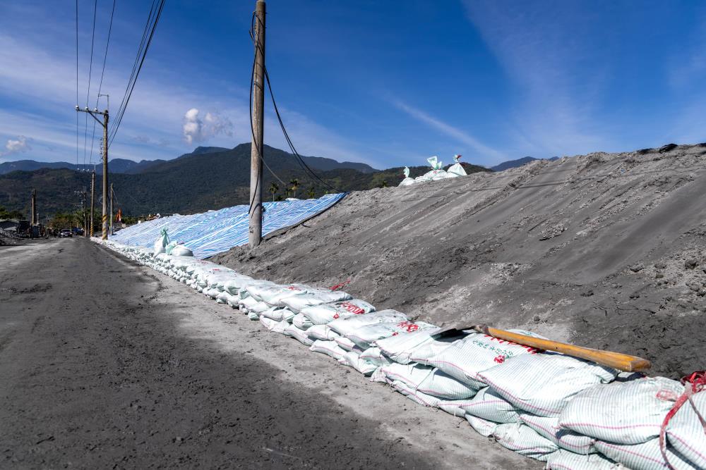 「削斜防水」作業，加強土堤坡面結構穩定。（軍聞社記者蔡枋澐攝）