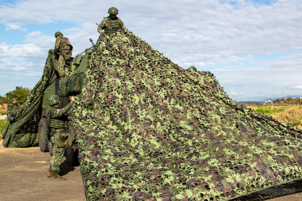 官兵針對甲車實施偽裝。（軍聞社記者王進福攝）