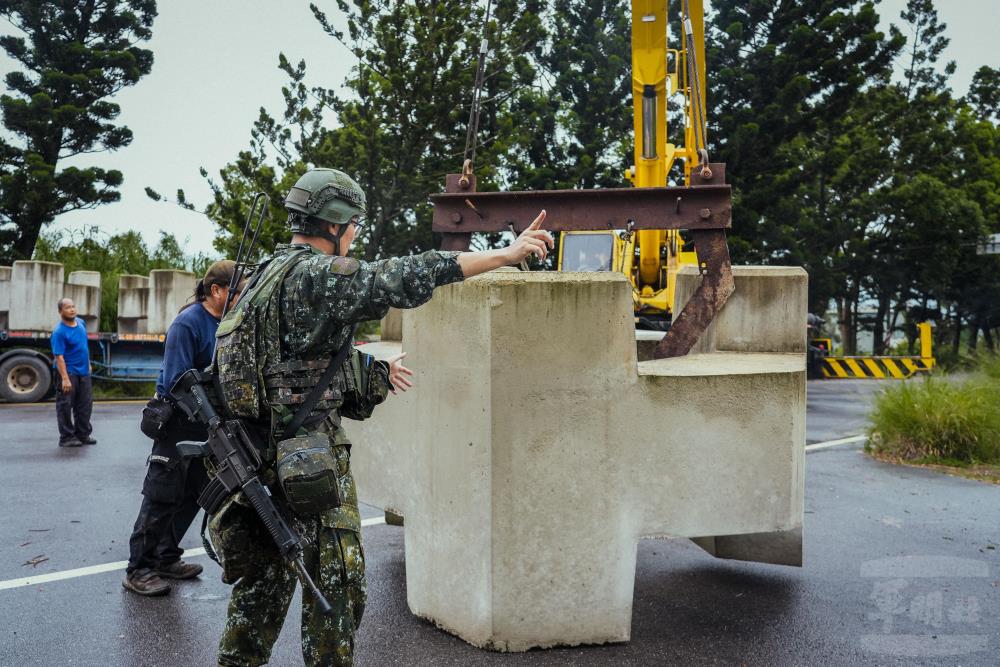 官兵引導吊車施放消波塊。（軍聞社記者陳傳奇攝）
