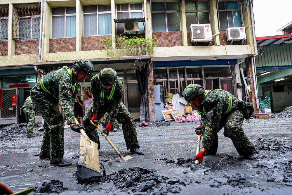 第二作戰區官兵執行街道淤泥清理。（軍聞社記者劉哲宇攝）