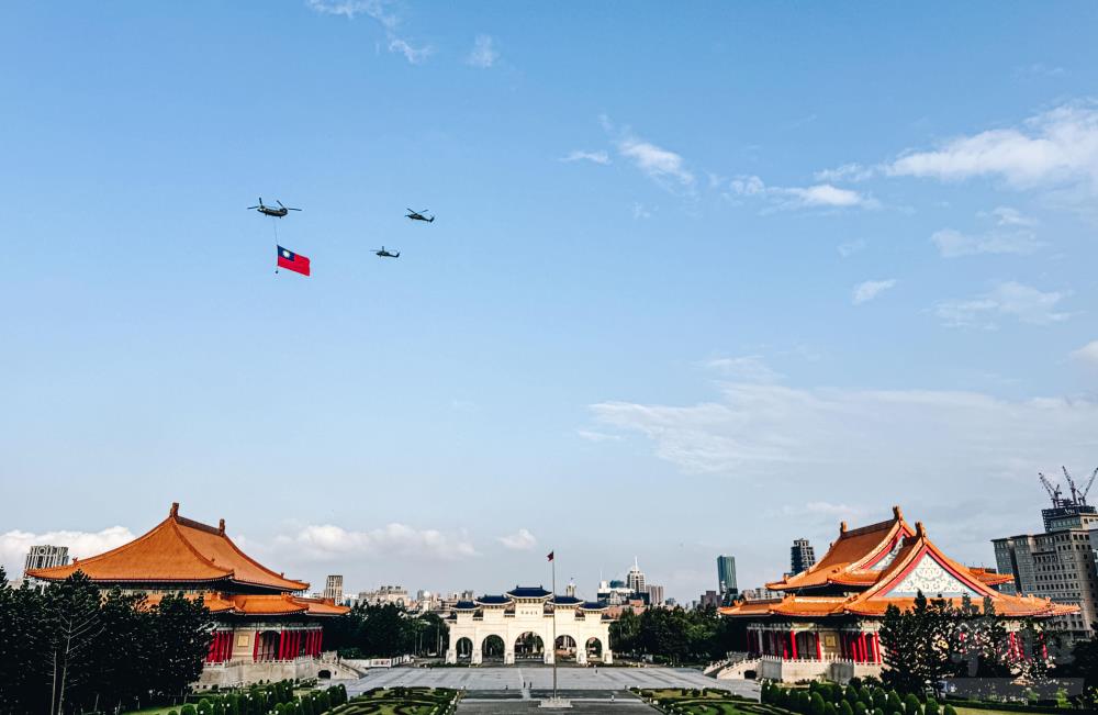 陸軍CH-47SD運輸直升機吊掛巨幅國旗，與UH-60M黑鷹直升機組成國旗機隊。（軍聞社記者陳軍均攝）