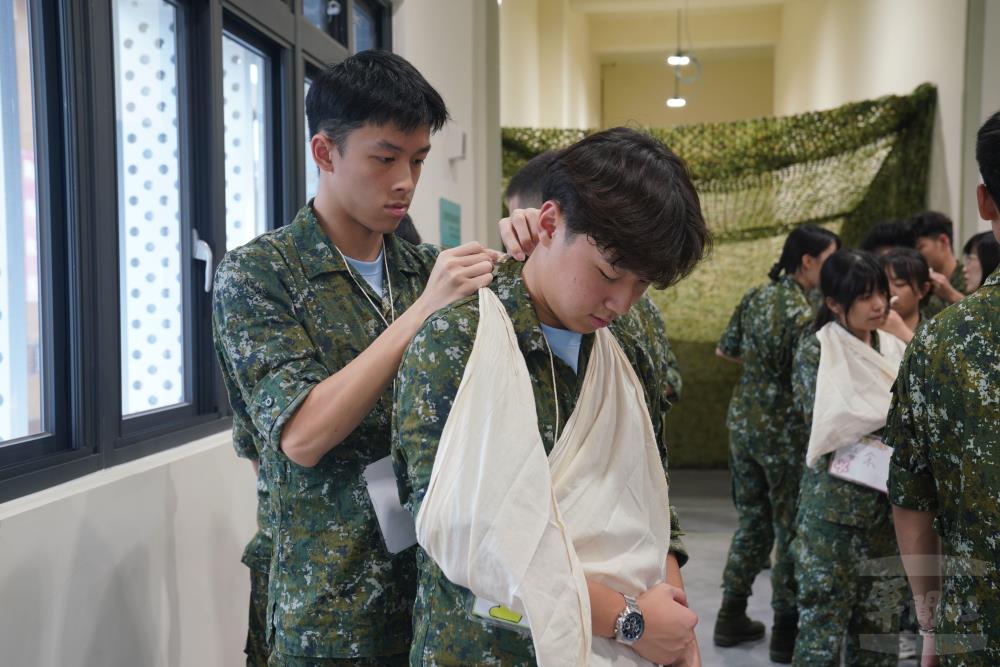 學員兩人一組，以三角巾包紮、固定患處。（軍聞社記者侯凱議攝）