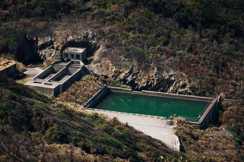 水庫旁錯落的石壁，仍可看見過往駐軍官兵辛勤開鑿的痕跡。（軍聞社記者吳東昇攝）