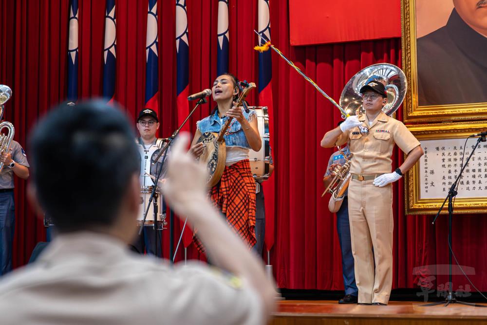 戴曉君以渾厚動人的嗓音領銜，結合月琴樸實清脆的樂音、軍樂隊嘹亮震撼的銅管聲，共譜動人樂聲。（軍聞社記者尤昱翔攝）