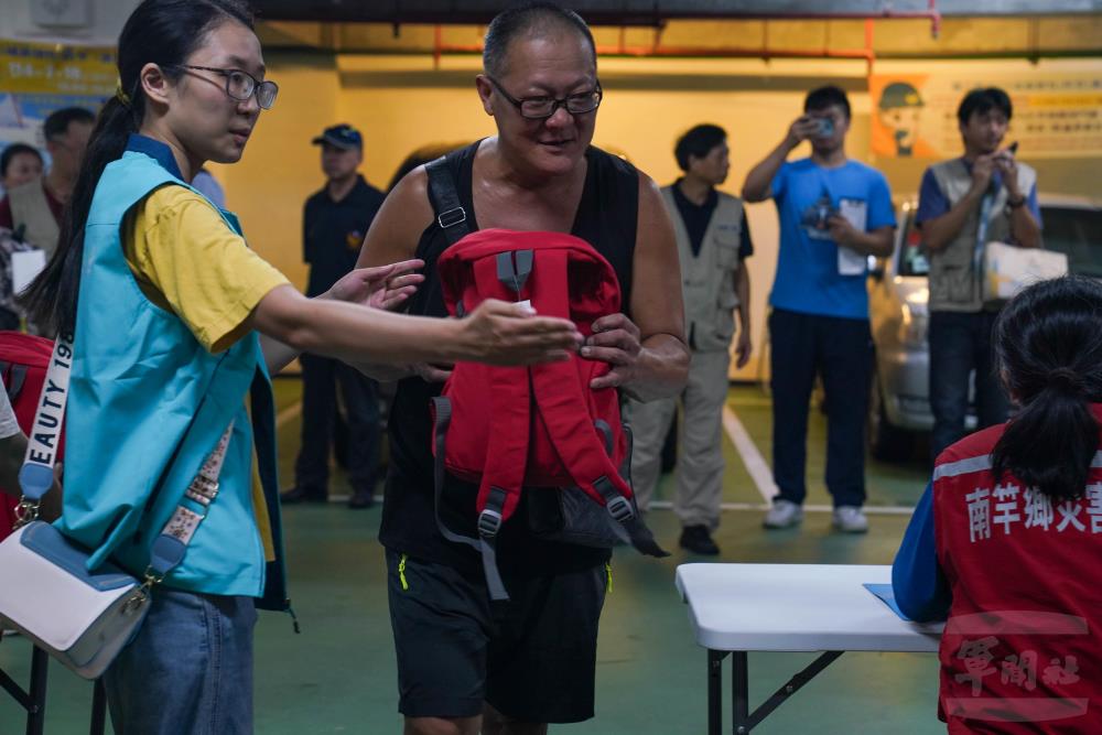 防災人員發放緊急避難包。（軍聞社記者侯凱議攝）