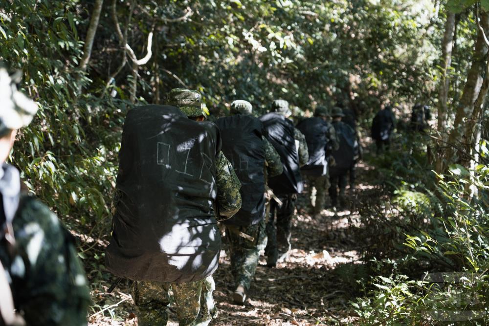 學員背負約40公斤的重裝挺進山區。（軍聞社記者李恬恬攝）