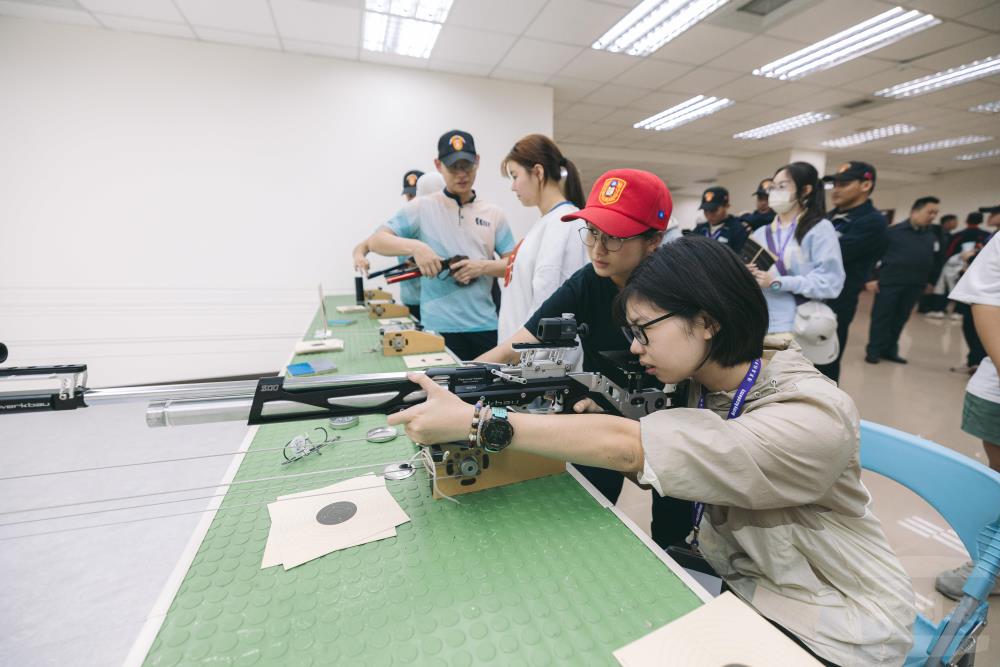 學子體驗空氣槍射擊，專注瞄準與擊發。（青年日報提供）