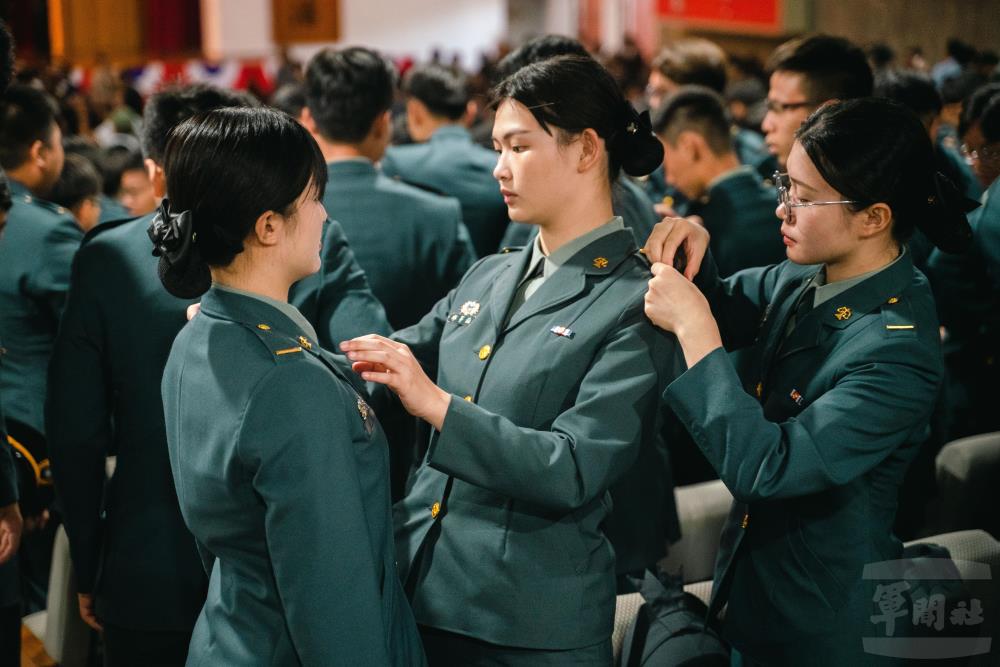 畢業生互相為彼此掛上少尉軍階。（軍聞社記者林庭暉攝）