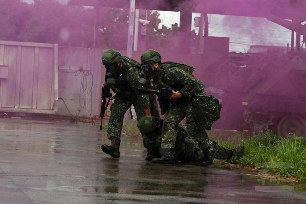 官兵協助受汙染人員脫離汙染區域。（青年日報提供）