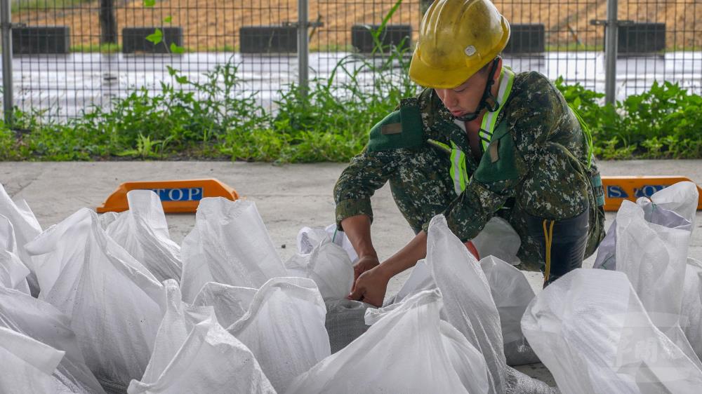 官兵將沙袋完成包裝。（軍聞社記者侯凱議攝）