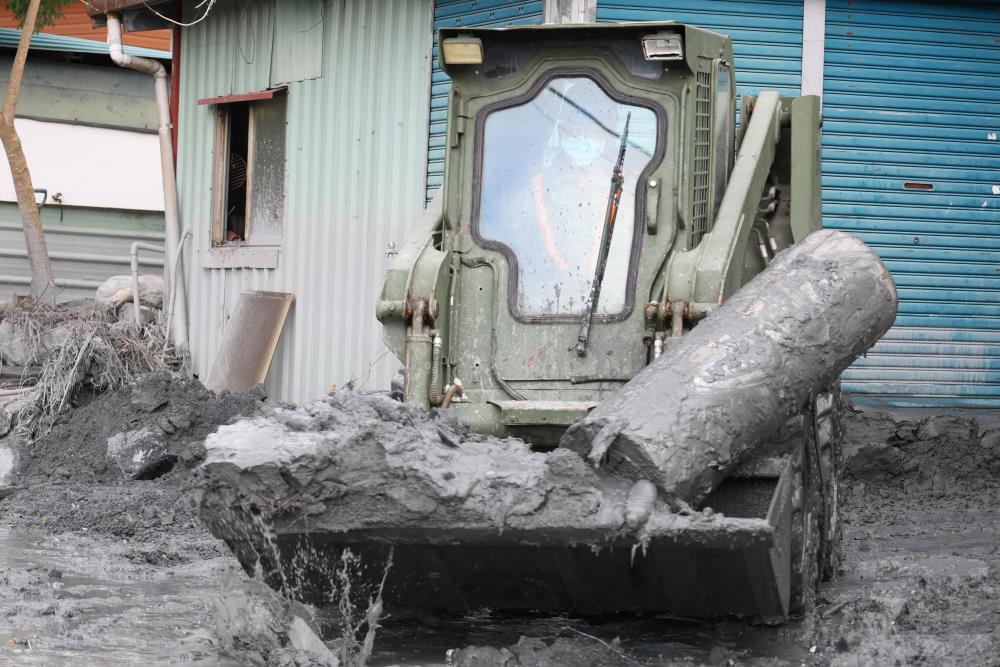 工兵部隊駕駛鏟裝機協助家園清淤。（第二作戰區提供）
