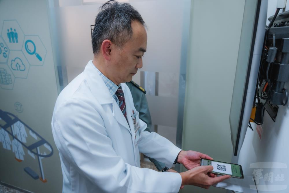 蒙恩副院長現場以App掃描QR Code，展示24小時自助領取制服功能。（軍聞社記者劉哲宇攝）