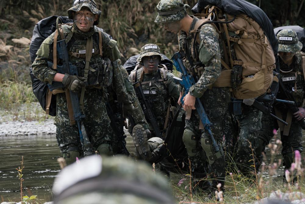 學員以多人搬運方式，運送傷患渡河。（軍聞社記者李恬恬攝）