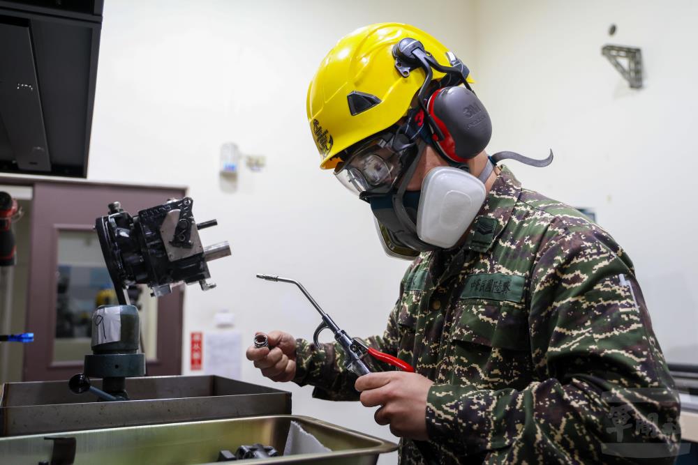 使用高壓空氣清洗燃油泵零件時，需配戴呼吸防護器具、護目鏡、耳罩等，確保人員安全。（軍聞社記者蔡枋澐攝）