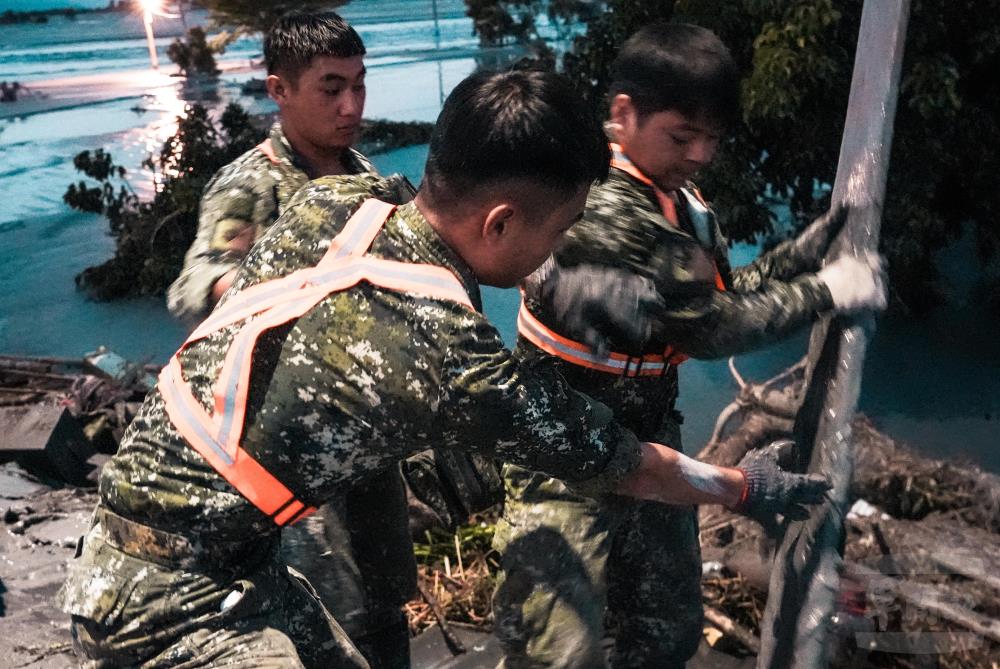 官兵協助將廢棄物移出建築。（軍聞社記者陳傳奇攝）