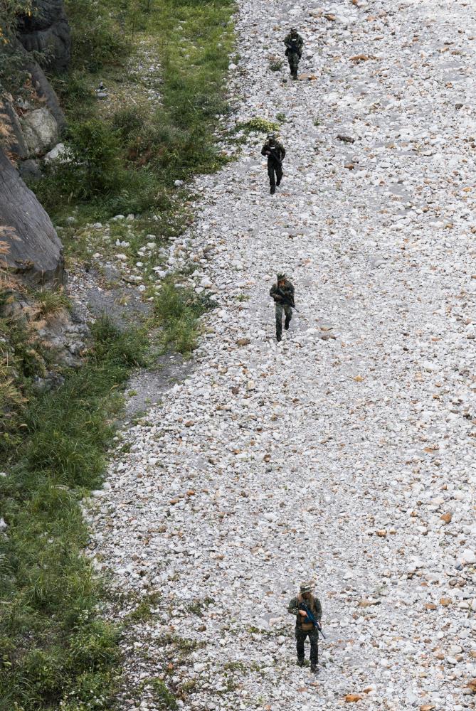 偵察組沿大甲溪河道探勘重要地形要點。（軍聞社記者李恬恬攝）