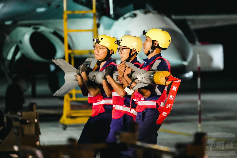 武掛分隊官兵攜手協力抬起AIM-9P4響尾蛇飛彈。（軍聞社記者林庭暉攝）