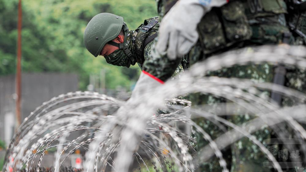 官兵架設阻絕器材。（軍聞社記者陳軍均攝）