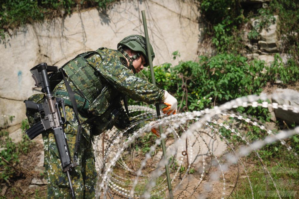 官兵架設蛇腹型鐵絲網。（軍聞社記者文仁攝）