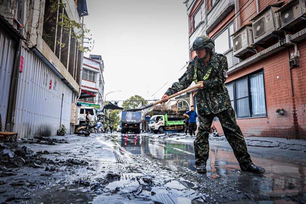 第二作戰區官兵執行街道淤泥清理。（軍聞社記者劉哲宇攝）
