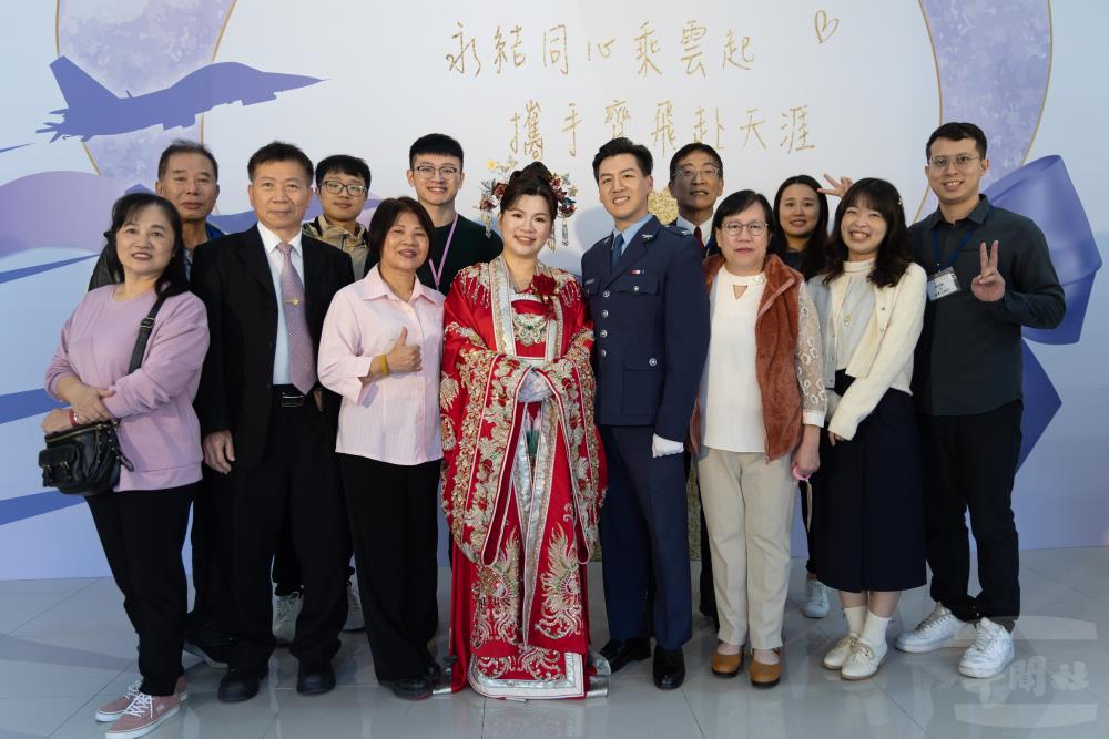 新人與寶眷們於特色打卡牆前合影。（軍聞社記者蔡枋澐攝）