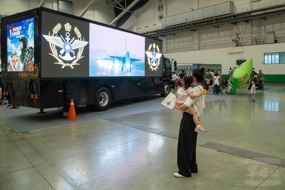 國防部大型文宣車在現場播放國軍形象影片，家長駐足觀賞。（軍聞社記者王進福攝）