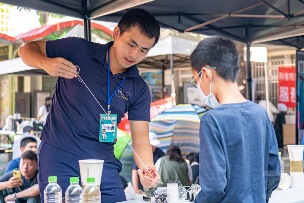 空軍官校學生帶領學童體驗陀螺儀原理。（軍聞社記者林庭暉攝）