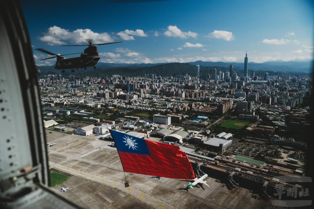 CH-47SD直升機吊掛巨幅國旗。（軍聞社記者文仁攝）