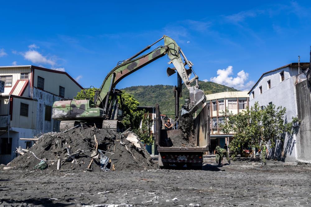 工兵部隊將先前暫置於路邊的淤泥統一集中至堆置場。（軍聞社記者蔡枋澐攝）