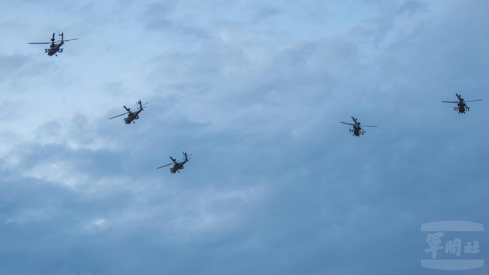 5架AH-64E阿帕契攻擊直升機以大雁隊形飛越球場上空。（軍聞社記者王進福攝）