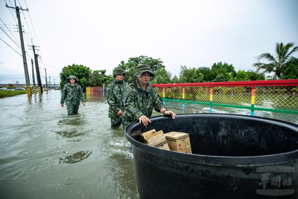 空訓中心官兵涉水徒步約1公里，將飲用水、乾糧及生活必需品送至受困民眾家中。（軍聞社記者王茗生攝）