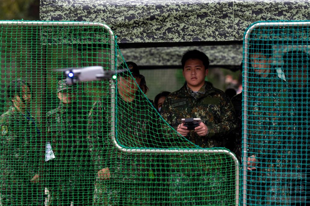 學員們手持操控器，親身體驗戰場偵察的視角。（軍聞社記者吳東昇攝）