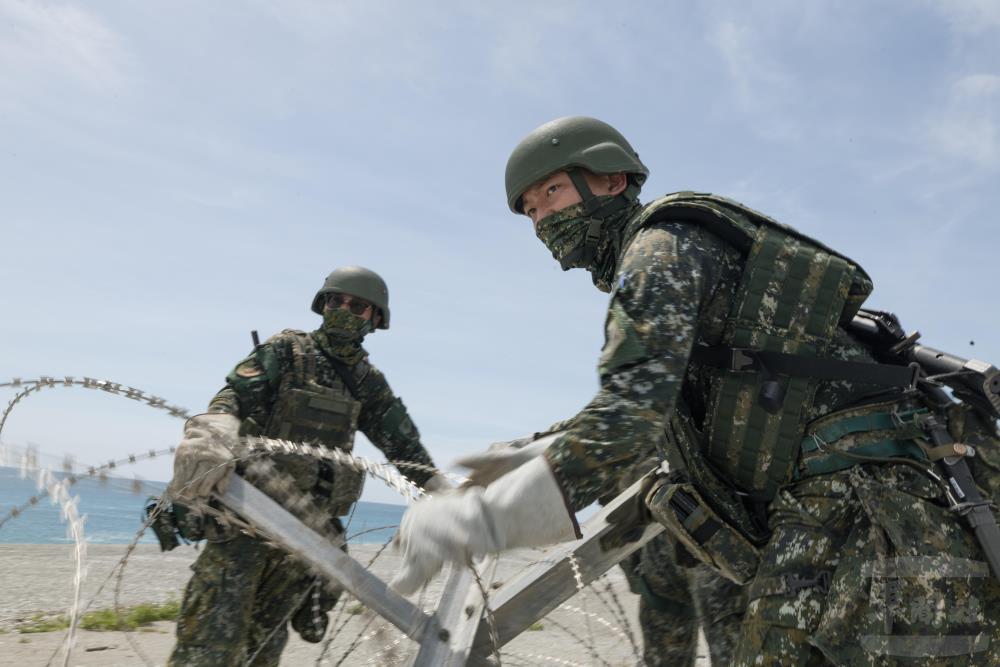 官兵架設蛇腹型鐵絲網。（軍聞社記者李恬恬攝）