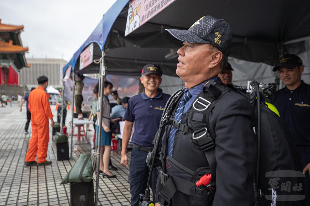 副部長柏鴻輝背上水下作業大隊執行任務的裝備，負重感受其重量。（軍聞社記者陳軍均攝）